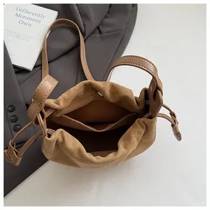 Detailansicht der Reißverschlussinnentasche und Kordelzug-Design der braunen Wildledertasche