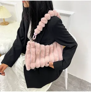 Détail du sac à bandoulière en fausse fourrure rose avec sangle unique en pompons doux