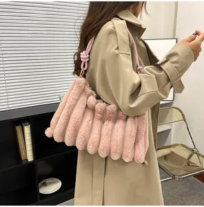 Détail du sac à bandoulière en fausse fourrure rose avec texture rayée et bandoulière nouée
