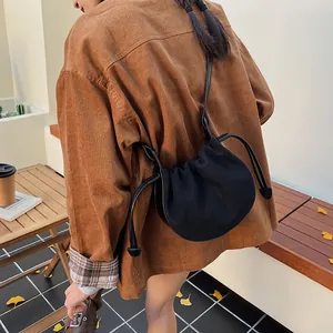 Retro schwarze Canvas Kordelzug Halbmond Schultertasche am Model in lässiger Umgebung