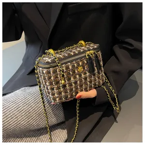 Dettaglio borsa a scatola in tweed con motivo trapuntato e camelia dorata
