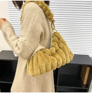 Détail d'un sac porté épaule en peluche camel avec plis verticaux et bandoulière