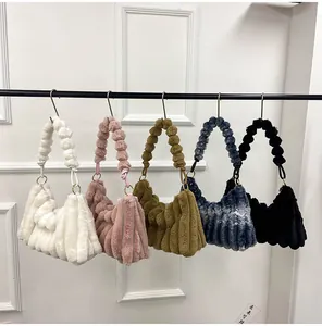 Détail de sacs plissés en peluche de différentes couleurs avec poignées en perles douces