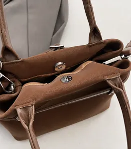 Detail of vintage brown bucket bag with secure magnetic buckle and clean stitching