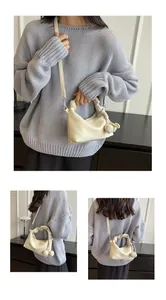 Three views showing a cream pleated cloud bag with knotted tassels and thin strap