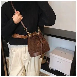 Detailed view of dark brown plush bucket bag with number 25 embroidery and drawstring close