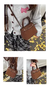 Close-up of a dark brown suede bucket bag featuring strap details and a metal lock buckle