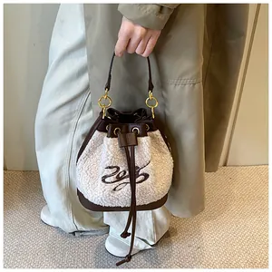 Close-up of plush shearling bucket bag with leather trim and gold drawstring hardware