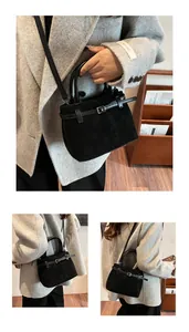 Macro detail of black matte bucket bag featuring leather handle and belt buckle accents