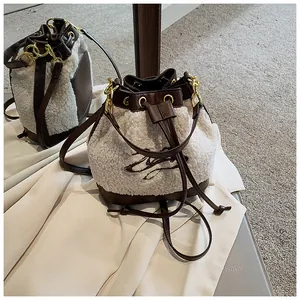 Detailed view of plush bucket bag featuring brown leather trim and floral embroidery