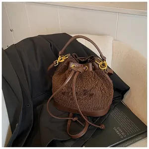 Detail of brown plush bucket bag showing shearling texture and leather trim accents