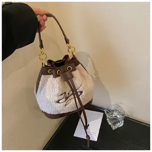 Detail of winter bucket bag with cream faux shearling texture and brown leather trim