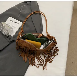 Internal capacity of brown suede tassel bag showing phone, wallet and cosmetics