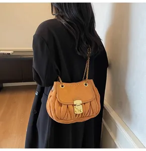 Detail of retro pleated shoulder bag with gold chain strap shown on model back
