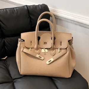 Detailansicht der beigen Handtasche aus Leder mit goldener Schließe und Narbung