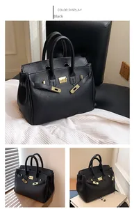 Detail der schwarzen Tote-Bag aus Leder mit goldenem Verschluss und schützenden Bodenbeschlägen