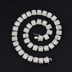 Macro shot of 15mm silver Cuban link necklace with iced out baguette crystals on black background