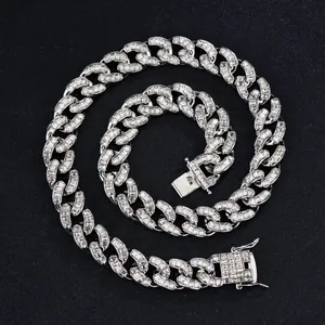 Iced out 15mm silver Cuban link necklace with baguette-cut diamonds on black background