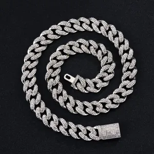 Iced out 15mm Cuban link necklace with sparkling rhinestones on textured black background