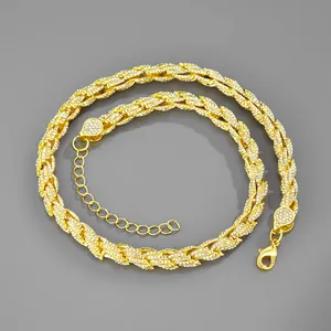 Dettaglio della catena dorata a maglia intrecciata con strass bianchi brillanti
