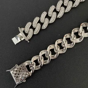 Detail of 19mm silver Cuban chain with rhinestones and textured square buckle on black surface