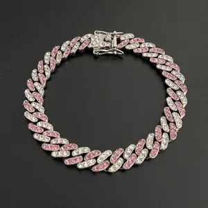 Detail of silver Cuban link chain with alternating pink and white zircons on black background