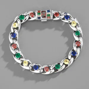 Dettaglio del bracciale cubano hip hop con zirconi colorati su superficie grigia