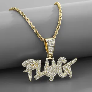 Detalle del colgante PLUG dorado hip-hop con circonitas sobre cadena de cuerda