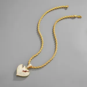 Dettaglio della catena hip hop dorata con ciondolo a cuore spezzato e strass luccicanti