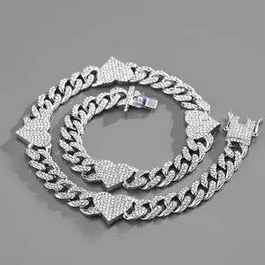 Macro view of iced-out silver Cuban link chain necklace and bracelet with heart pendants