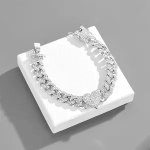 Detail of silver Cuban link bracelet with heart centerpiece and sparkling pavé stones