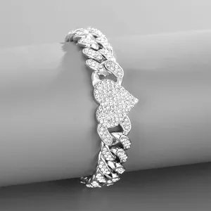 Detailed view of silver iced-out Cuban link bracelet with heart charm on a gray stand