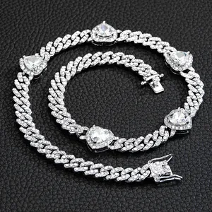 Macro shot of silver Cuban link necklace and bracelet set with iced-out heart stones