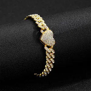 Macro shot of gold Cuban chain necklace featuring an iced-out heart centerpiece with clear crystals