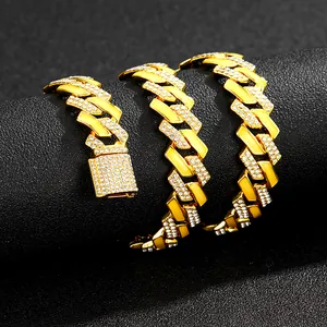 Detail of 15mm gold Cuban link necklace with crystal pavé on a textured black display