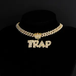 Detail of gold Cuban link chain with a full iced out TRAP crown letter pendant