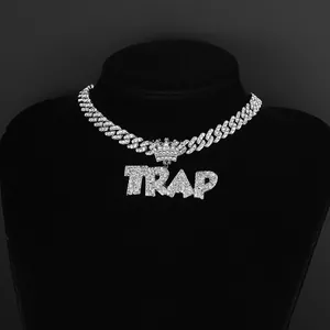 Close-up of iced out silver Cuban chain with crystal TRAP crown pendant on display