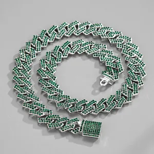 Macro detail of silver-tone Cuban link necklace with iced-out green crystals and box clasp