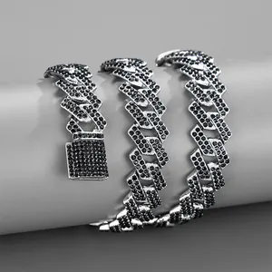 Detailed close-up of wide silver Cuban link chain with paved black zircon stones and box clasp