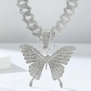 Detail van hiphop ketting met vlinderhanger ingelegd met zirkonia op een cubaanse schakel