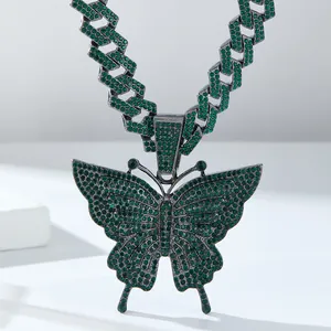 Macro-opname van hiphop-vlinderhanger met groene strasstenen op een dikke cuban chain