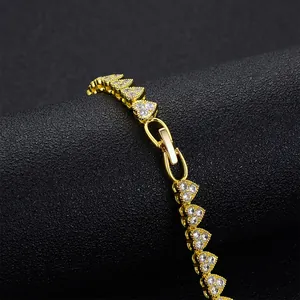 Bracelet élégant à maillons cœur dorés avec zircons sur un support texturé noir
