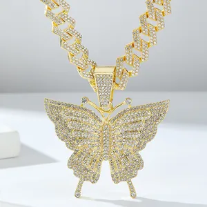 Macro-opname van gouden vlinderhanger met strassteentjes aan een dikke Cubaanse ketting