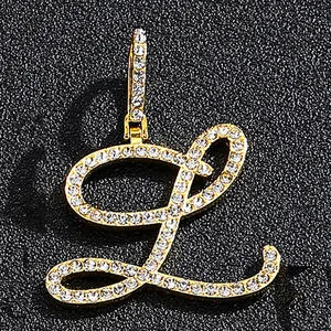 Iced out gold letter L pendant with pavé crystals on a black textured background