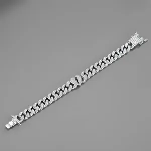Close-up of iced out Cuban link bracelet featuring a broken heart pendant and safety buckle