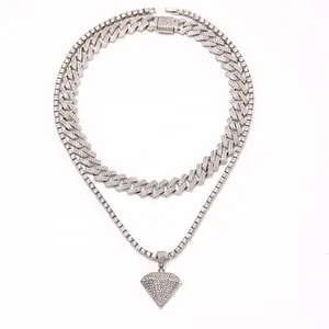 Detalle del conjunto de cadena cubana y de tenis plateada con colgante de diamante