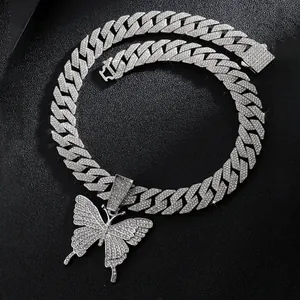 Close-up of sparkling silver butterfly pendant on iced out Cuban link chain necklace