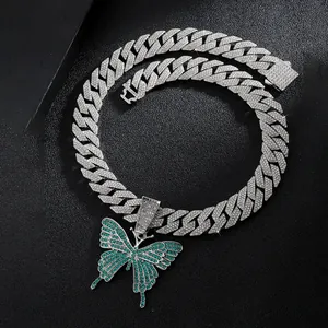 Macro shot of a Cuban link necklace featuring a butterfly pendant with green stones and rhinestones