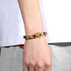 Detail of gold Cuban chain bracelet with colorful square zircons and secure clasp