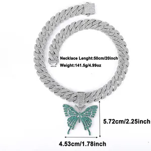 Macro detail of iced-out Cuban link chain with a large green butterfly pendant